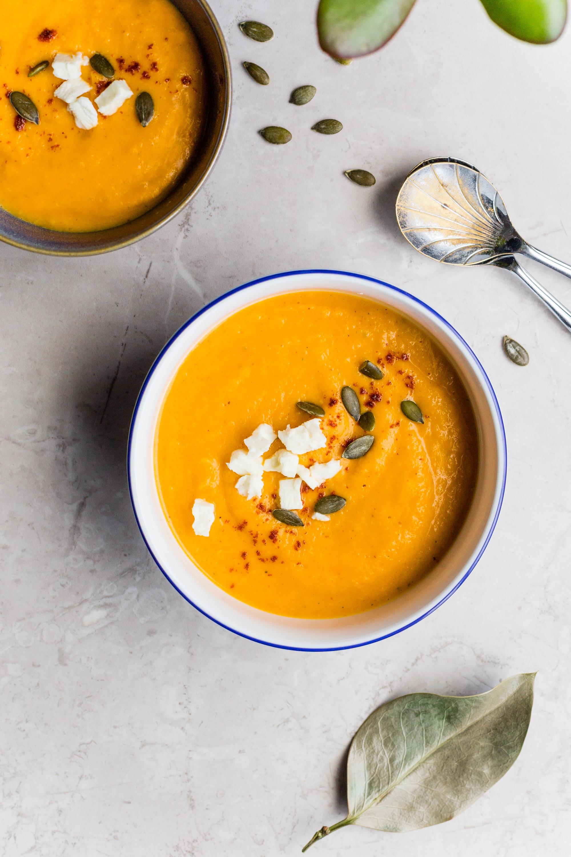 two bowls of an orange colored soup