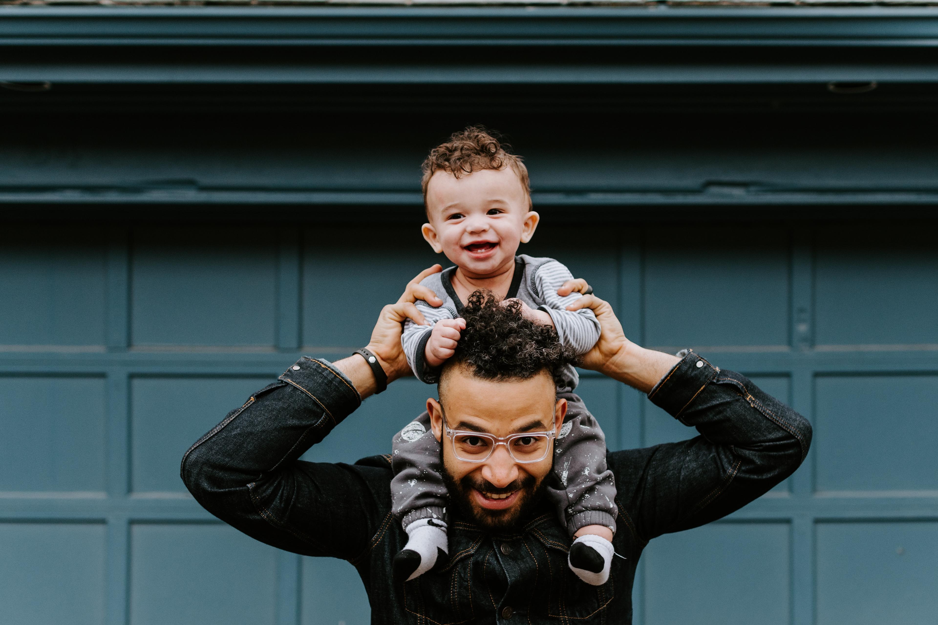 man with carrying child on his shoulders