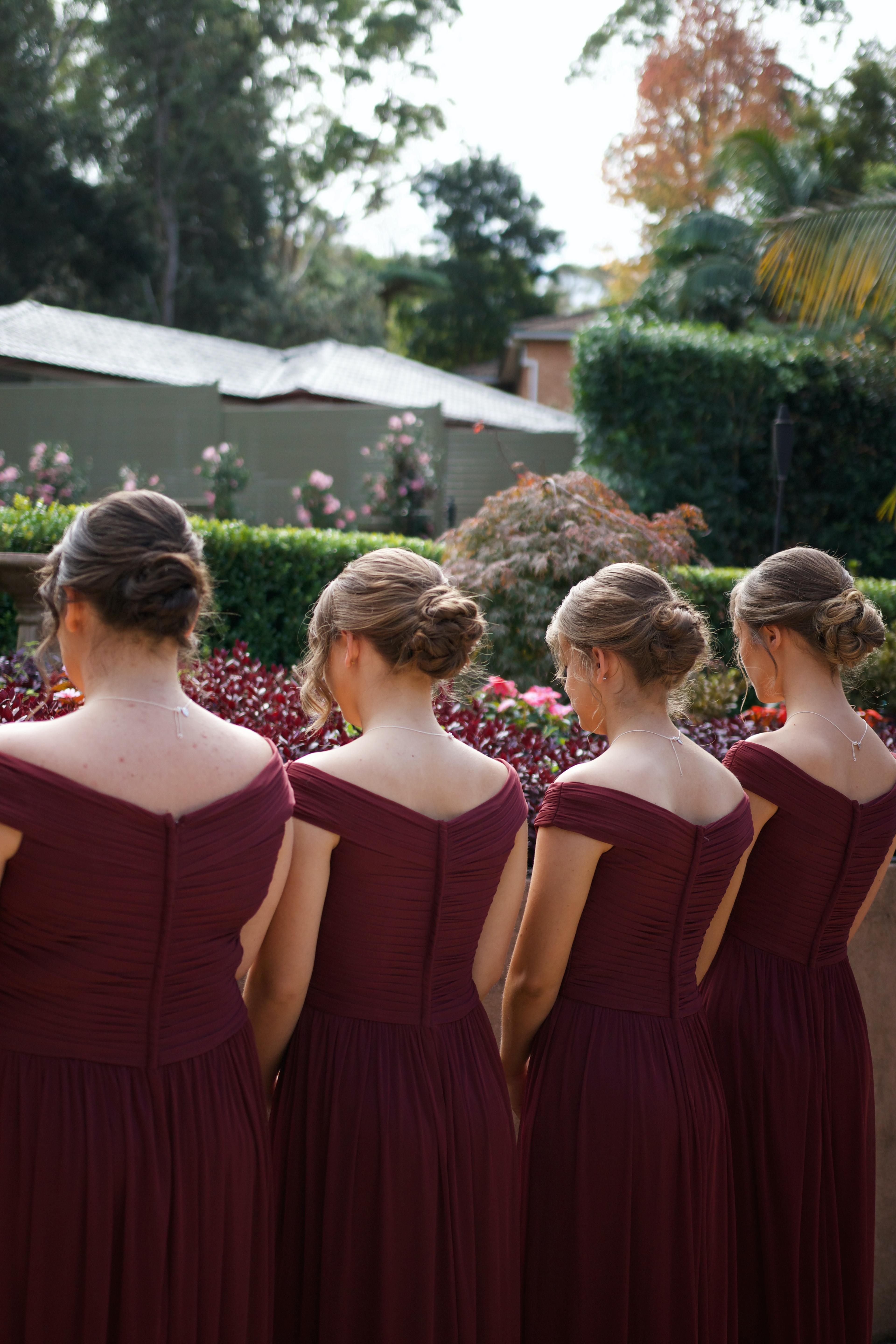 four bridesmaids wearing red facing away from camera